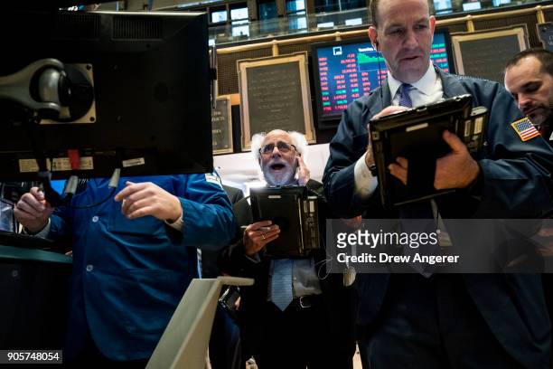 Traders and financial professionals work on the floor of the New York Stock Exchange ahead of the closing bell, January 16, 2018 in New York City....