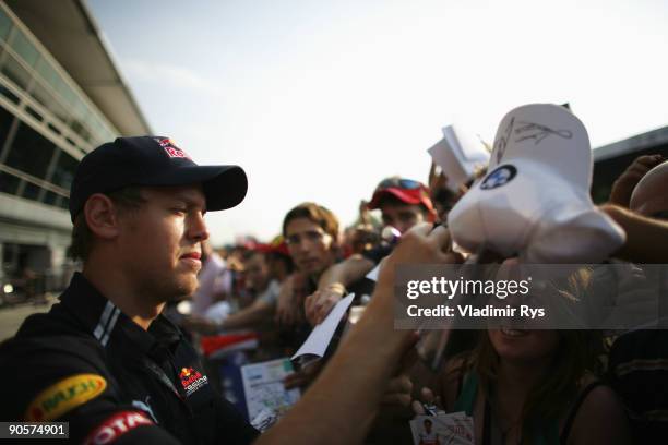 Sebastian Vettel of Germany and Red Bull Racing signs autographs at the drivers autograph session during previews to the Italian Formula One Grand...