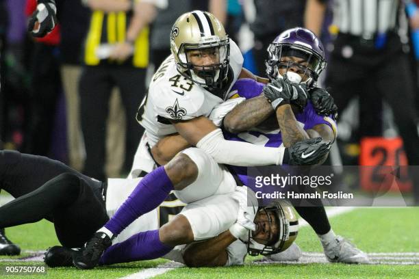 Craig Robertson and Marcus Williams of the New Orleans Saints tackle Jerick McKinnon of the Minnesota Vikings during the second half of the NFC...