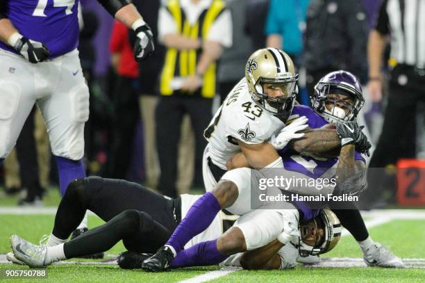 Craig Robertson and Marcus Williams of the New Orleans Saints tackle Jerick McKinnon of the Minnesota Vikings during the second half of the NFC...