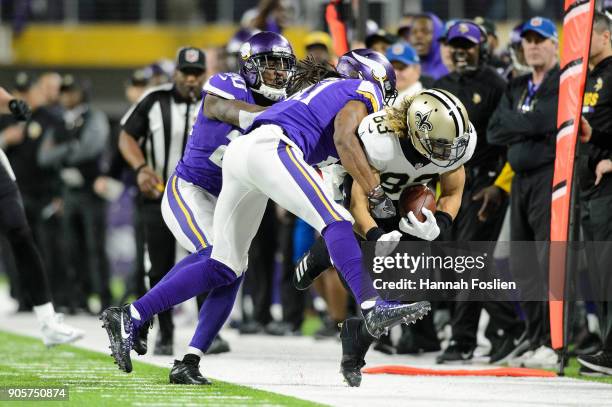 Mackensie Alexander and Anthony Harris of the Minnesota Vikings push Willie Snead of the New Orleans Saints out of bounds during the second half of...