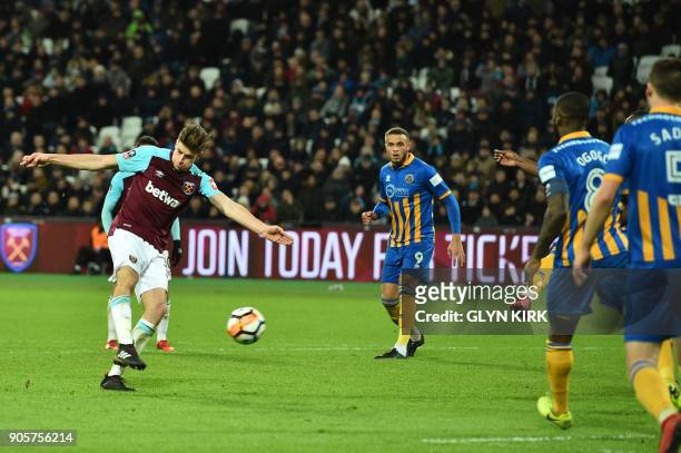 West Ham United's English defender Reece Burke scores the team's first goal during the FA Cup third round replay football match between West Ham...