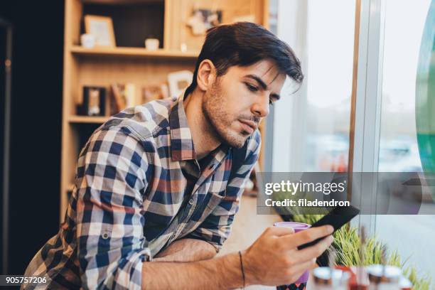 uomo che sms al bar - topnews foto e immagini stock