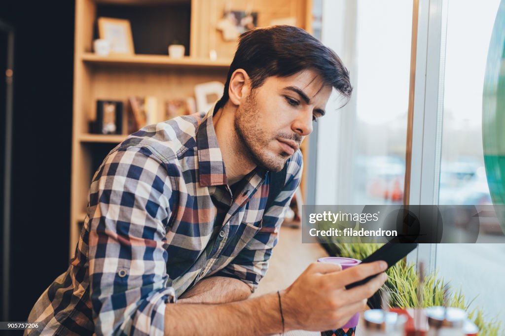 Man texting at the cafe