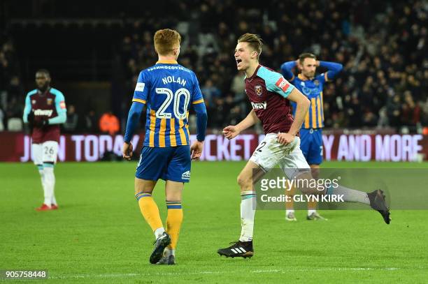 West Ham United's English defender Reece Burke celebrates scoring the team's first goal during the FA Cup third round replay football match between...