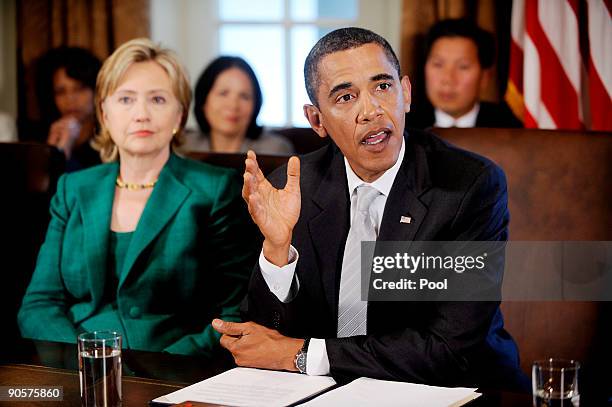 President Barack Obama speaks as Secretary of State Hillary Clinton looks on as he meets with members of the Cabinet in the Cabinet Room of the White...