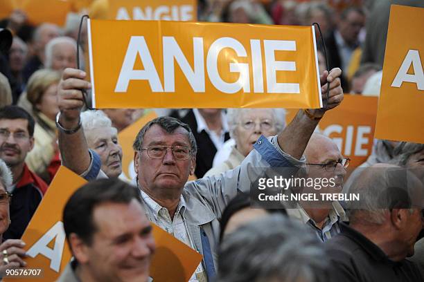 Supporters hold up placards reading "Angie" as German Chancellor Angela Merkel delivers a speech during an electoral meeting in Hannover, northern...
