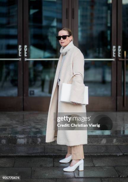 Celine Aagaard wearing white Marimekko shoes, Dorothee Schumacher pants and creme coat, white Celine bag, Celine sunglasses is seen during the Berlin...