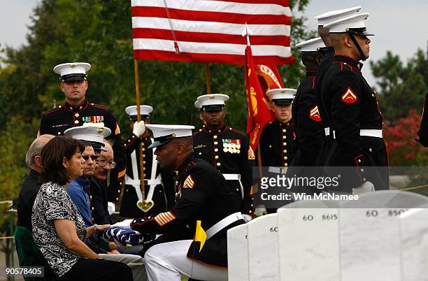 Judith Watters receives an American flag during burial services for her son Master Sgt. Adam Frank Benjamin, United States Marine Corps, from Sgt....