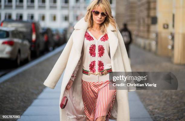 Gitta Banko wearing a cream-colored teddy bear coat by Stand, cream-colored cardigan by Steffen Schraut, asymmetrical skirt with knot details from...