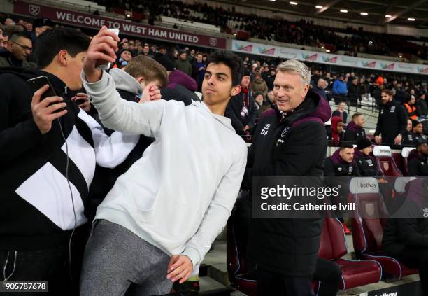 Fan takes a selfie photo with David Moyes manager of West Ham United during the Emirates FA Cup Third Round Replay match between West Ham United and...