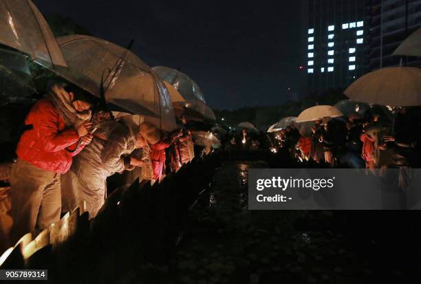Kobe residents gather around candles commemorating the 23rd anniversary of the Great Hanshin earthquake at a park in Kobe, Hyogo prefecture on...
