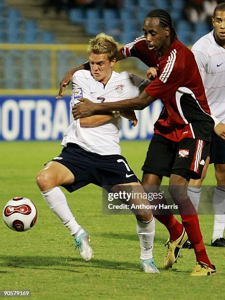 Keon Daniel of Trinidad Tobago fights for the ball with Stuart Holder of United States during their FIFA 2010 World Cup qualifier at the Hasely...