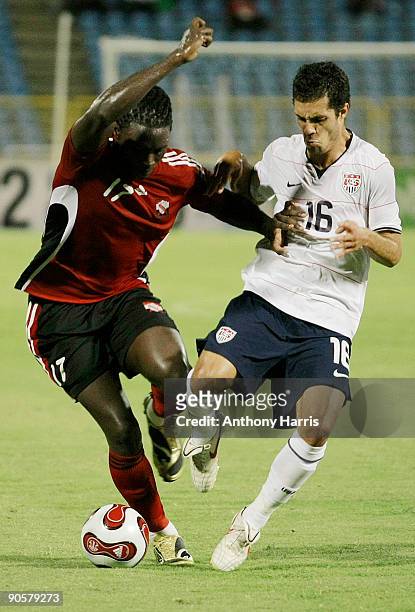 Kenwyne Jones of Trinidad Tobago fights for the ball with Benny Feilhaber of United States during their FIFA 2010 World Cup qualifier at the Hasely...