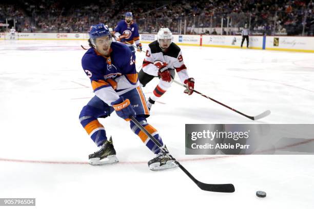 Mathew Barzal of the New York Islanders skates with the puck against Marcus Johansson of the New Jersey Devils in the first period during their game...