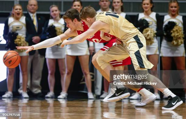 Ethan Happ of the Wisconsin Badgers and Ryan Cline of the Purdue Boilermakers chase down the loose ball during the game at Mackey Arena on January...