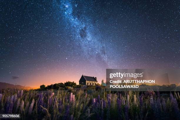 church of the good shepherd and milky way with lupins blooming, lake tekapo, new zealand - church of the good shepherd tekapo stock pictures, royalty-free photos & images