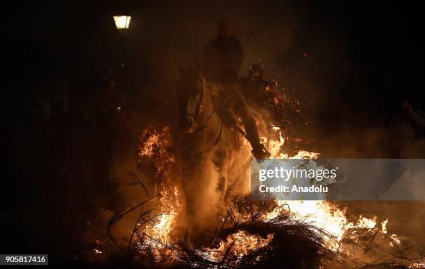 Man rides his horse through fire to purify and protect his horse during the Las Luminarias festival at the San Bartolome de Pinares village in...