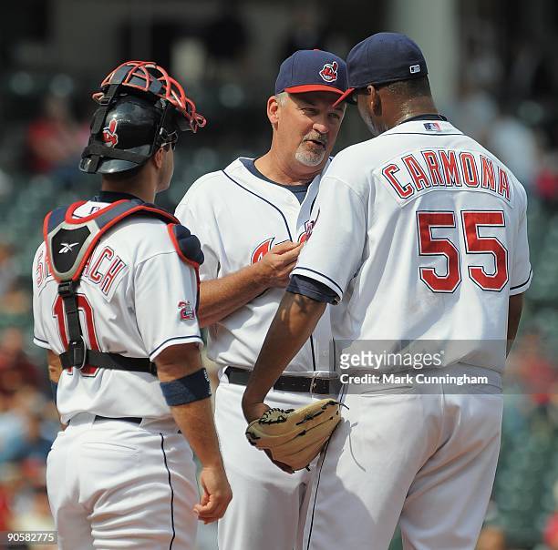 Cleveland Indians pitching coach Carl Willis talks with Kelly Shoppach and Fausto Carmona on the mound against the Texas Rangers during the game at...