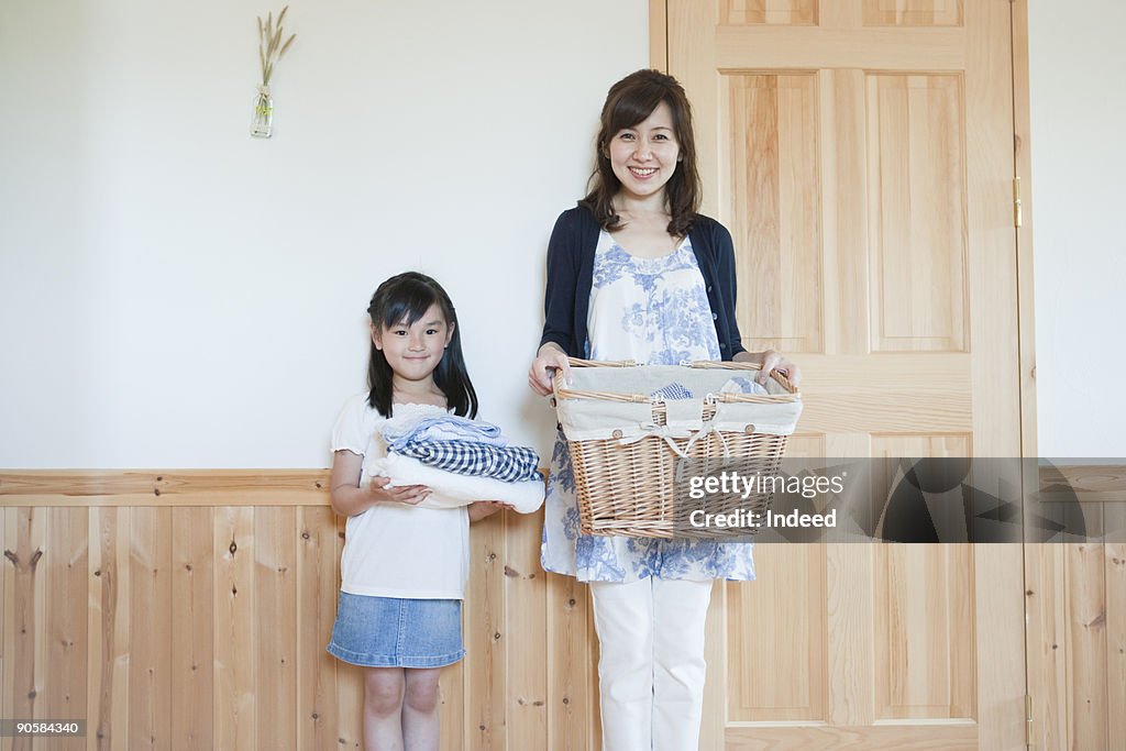 Motehr and daughter holding cloths and basket