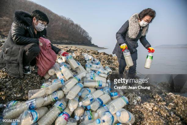 Activists prepare for the PET bottles before throwing them into the water on an island near the DMZ on January 17, 2018 in Incheon, South Korea. The...