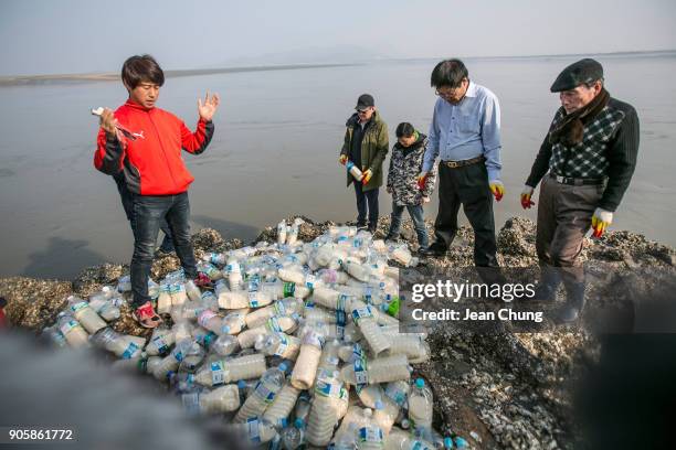 Activists pray throwing PET bottles on an island near the DMZ on January 17, 2018 in Incheon, South Korea. The human rights group organised by North...