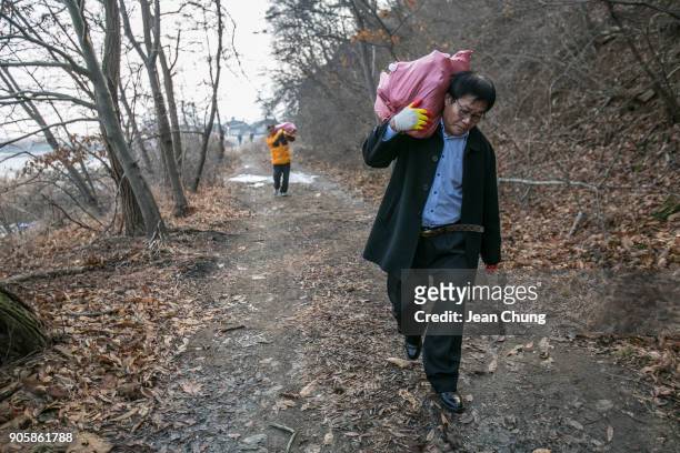 Activistscarry sacks containing PET bottles on an island near the DMZ on January 17, 2018 in Incheon, South Korea. The human rights group organised...