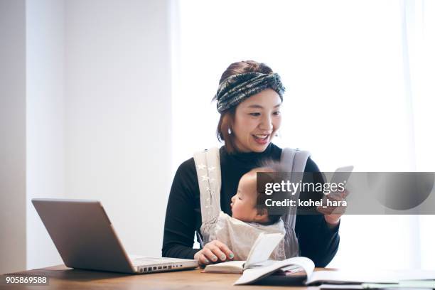 mother with baby working at home - baby smartphone stock pictures, royalty-free photos & images