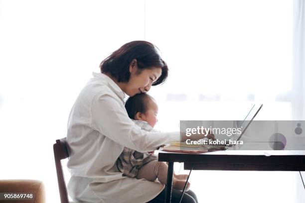 mother with baby working at home - flexibility work stock pictures, royalty-free photos & images