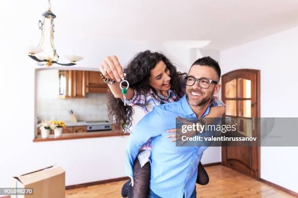 happy couple moving in new home - home ownership keys stock pictures, royalty-free photos & images