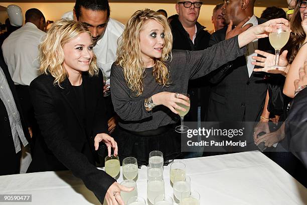 Designers Ashley Olsen and Mary-Kate Olsen hand-out drinks to celebrate the launch of The Row for men at the Barneys New York celebration for...