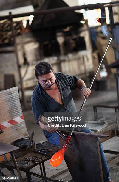Workman turns glass in a furnace on the island of Murano on September 10, 2009 in Venice, Italy. Traditional glass making became established on the...