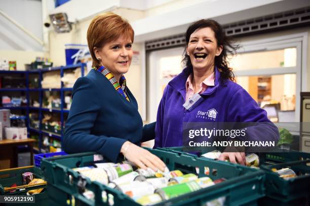 Scotland's First Minister Nicola Sturgeon meets volunteer Amy McBride as she visits the Start Up Stirling food bank in Stirling on January 17 2018. /...