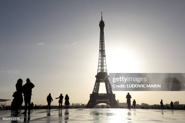 People walk on the Trocadero esplanade, also called Square of human rights with the Eiffel Tower on the back ground, in the morning of January 17 in...