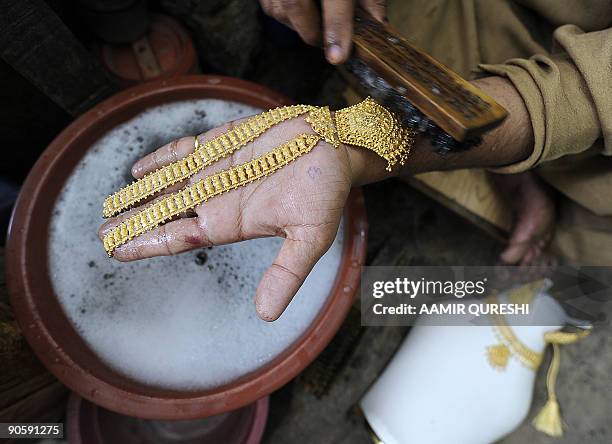 Pakistani worker polishes a necklace at his gold workshop in Rawalpindi on September 9, 2009. Gold prices in Pakistan on September 9 touched a...