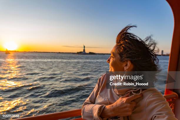 senior women on sunset near the statue of liberty - new york city - statue of liberty people stock pictures, royalty-free photos & images