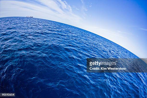 container ship on wide open ocean, horizon curved - westerskov stock pictures, royalty-free photos & images