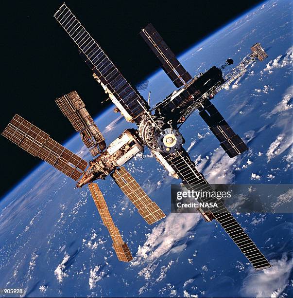 Russia's Mir Space Station backdropped against a cloud-covered Earth was photographed during a fly-around by the Space Shuttle Atlantis. On August...