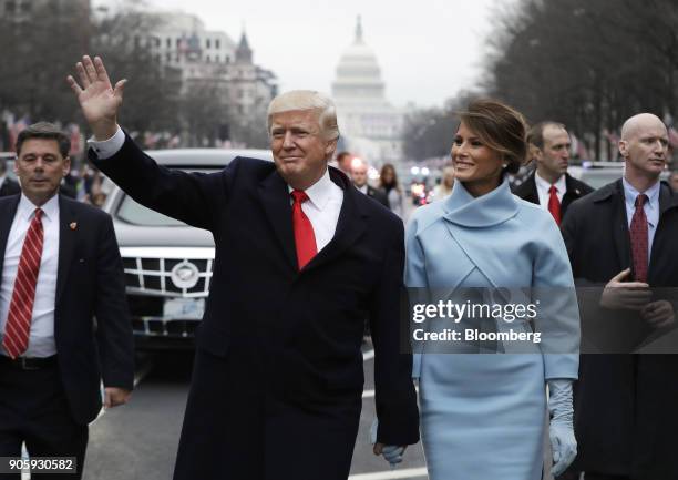 President Donald Trump waves while walking with U.S. First Lady Melania Trump during a parade following the 58th presidential inauguration in...