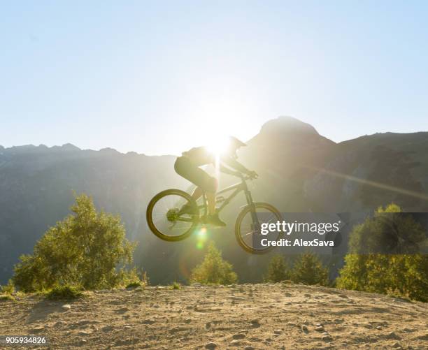 man flying in midair with mountain bike - alps romania stock pictures, royalty-free photos & images