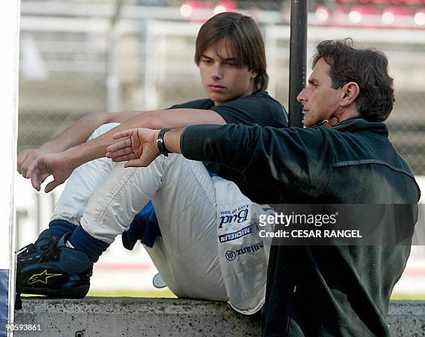 File photo taken on 03 Febrary 2004 shows Formula One former driver Nelson Piquet of Brazil speaking to his son, then Williams BMW test-driver Nelson...