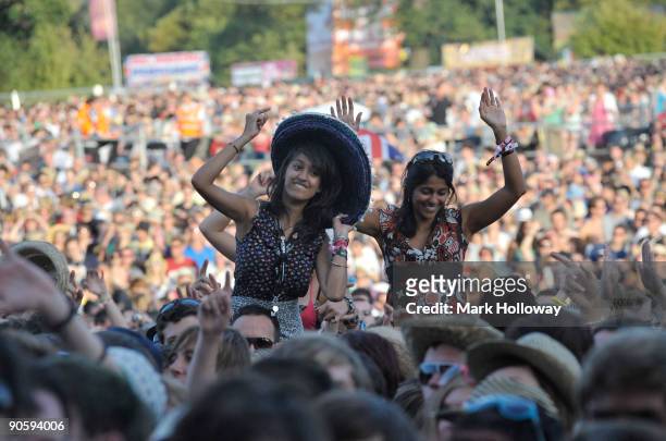 Two young women sit on shoulders above the crowd on the first day of V Festival at Hylands Park on August 22, 2009 in Chelmsford, England.