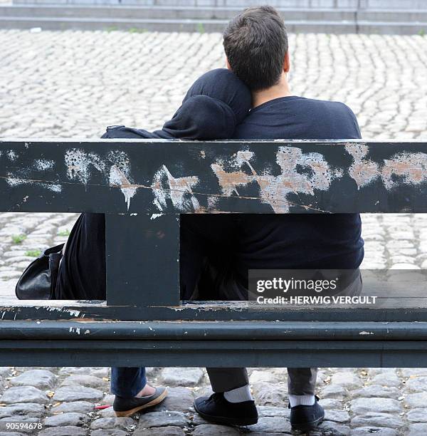 Young girl, wearing a head scarf, and her partner sit on a bench at the 'Martelarenplein place' - or Place des Martyrs- on September 11, 2009 in...