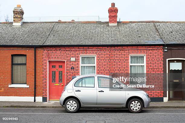 silver compact car parked outside brick home - front view of car stock pictures, royalty-free photos & images