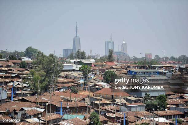 Modern highrise office blocks break the skyline above the sprawling Kibera slum in the foreground in the Kenyan capital, Nairobi, on January 16,...