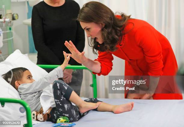 Catherine, Duchess of Cambridge reacts to patient Rafael Chana as she visits Great Ormond Street Hospital to officially open the Mittal Children's...