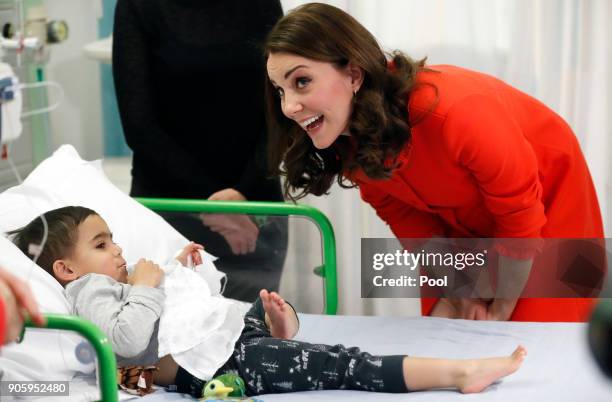 Catherine, Duchess of Cambridge reacts to patient Rafael Chana as she visits Great Ormond Street Hospital to officially open the Mittal Children's...