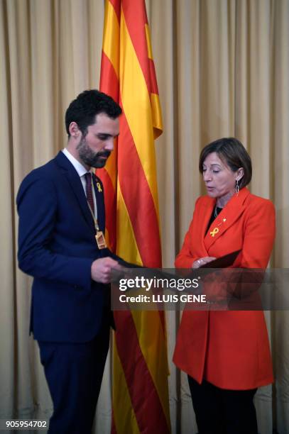 Newly elected parliament speaker Roger Torrent receives his briefcase from outgoing speaker Carme Forcadell after Catalan's parliament inaugural...