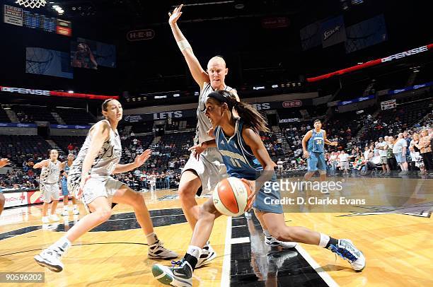 Candice Wiggins of the Minnesota Lynx drives to the basket past Ann Wauters and Ruth Riley of the San Antonio Silver Stars during the WNBA game on...