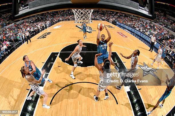 Charde Houston of the Minnesota Lynx puts a shot up over Helen Darling and Sophia Young of the San Antonio Silver Stars during the WNBA game on...